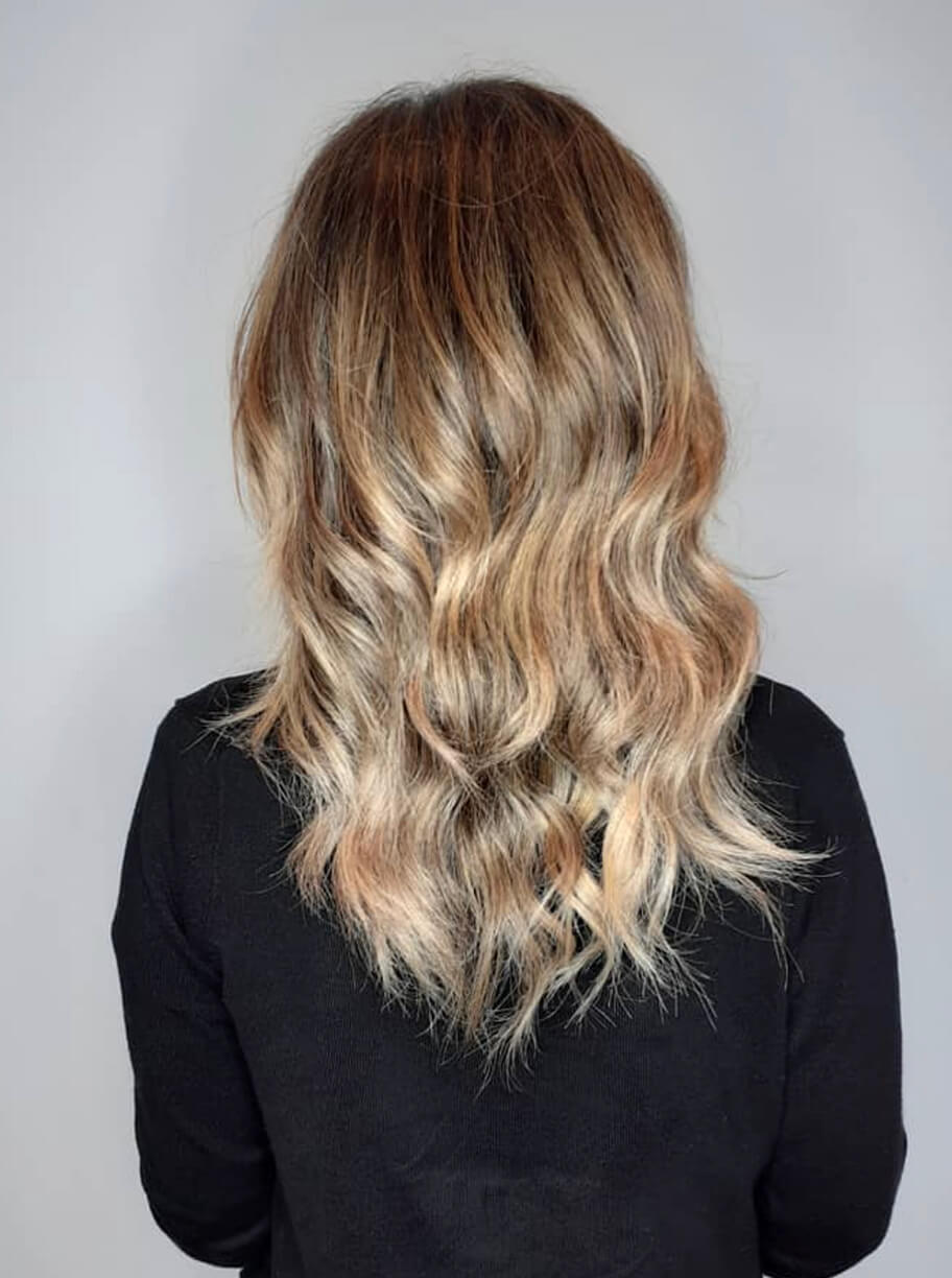 Imagen de galería de corte de pelo medio con ondas de mujer con color rubio