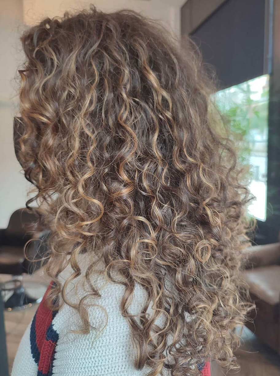 Imagen de galería de corte de pelo largo rizado de mujer con color rubio