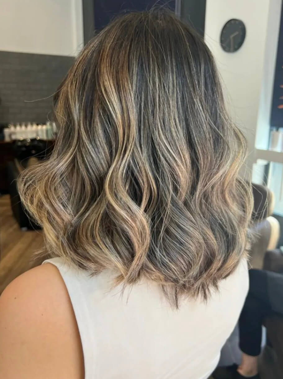 Imagen de galería de corte de pelo medio con ondas de mujer con color rubio