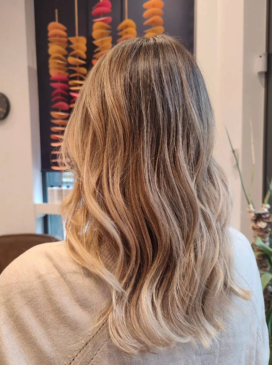 Imagen de galería de corte de pelo medio con ondas de mujer con color rubio