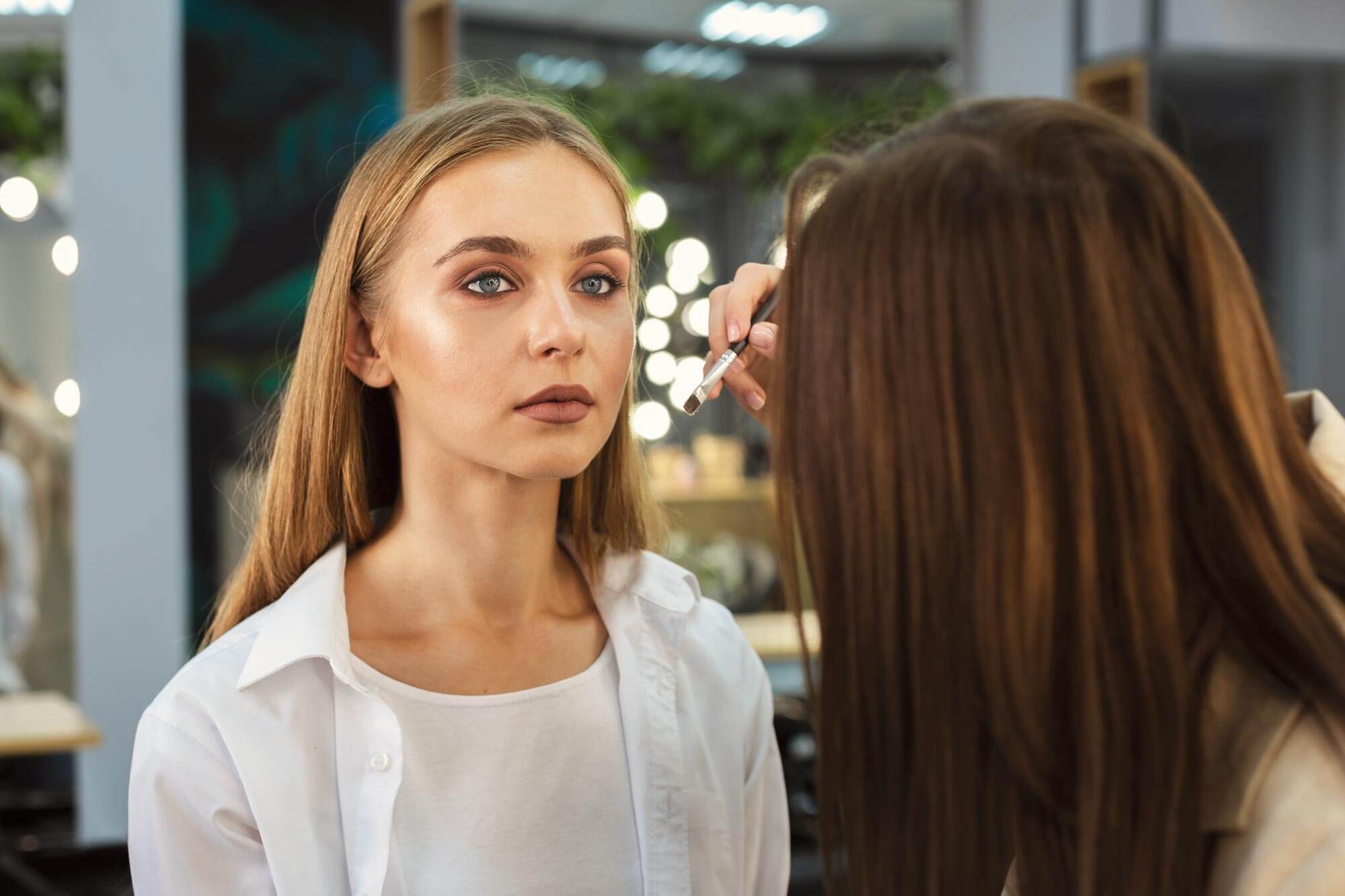 Imagen de una mujer rubia siendo maquillada